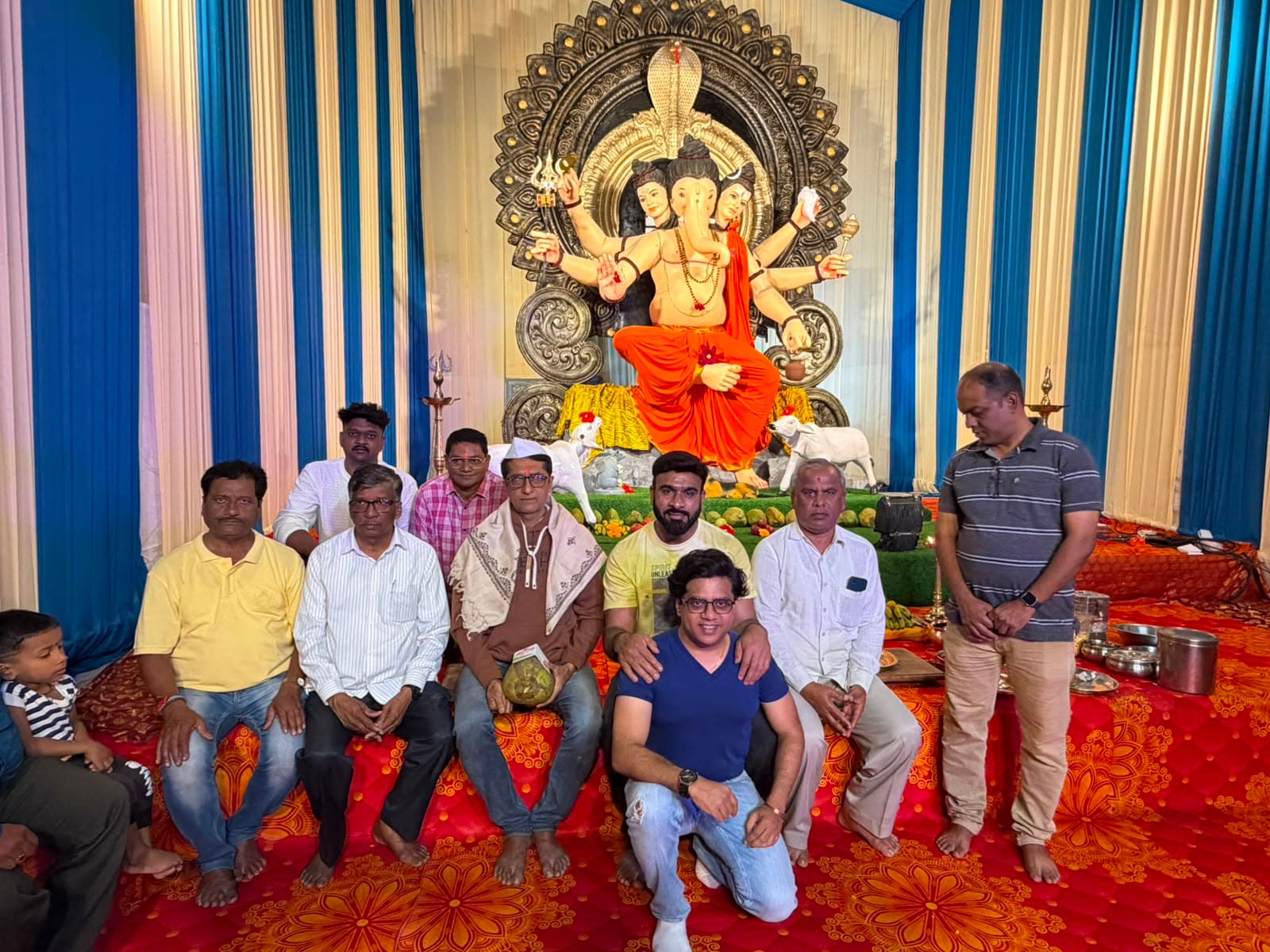 Group photo of mandal members and volunteers with the Ganpati idol after the Murtikar felicitation, 2026